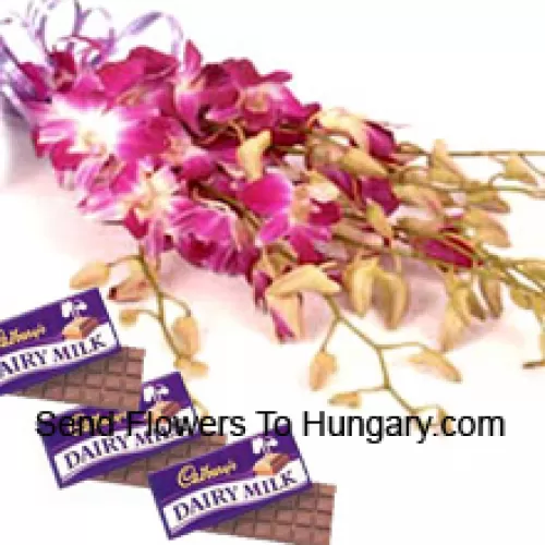 Un bel mazzo di orchidee rosa insieme a cioccolatini assortiti Cadbury