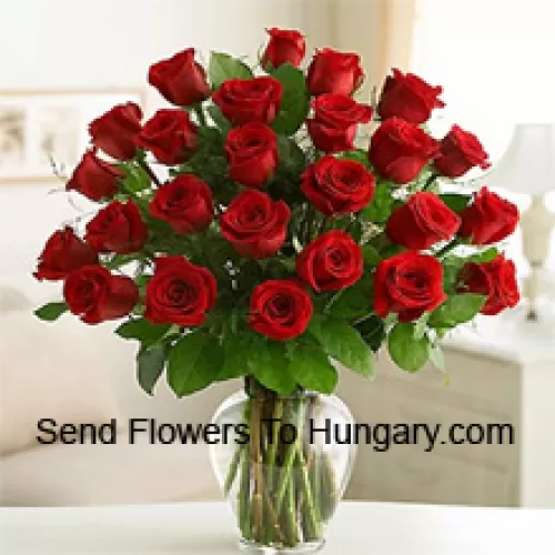25 roses rouges avec quelques fougères dans un vase en verre