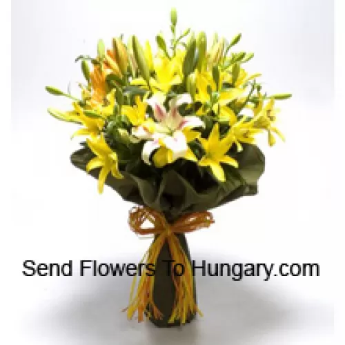 Un gros bouquet de lys jaunes et blancs avec des remplissages saisonniers