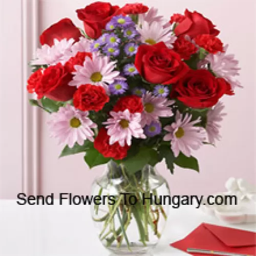 Roses rouges, œillets rouges et gerberas roses avec des remplissages saisonniers dans un vase en verre - 25 tiges et remplissages