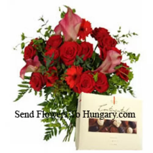 Gérberas rouges et roses rouges dans un vase accompagnés d'une boîte de chocolats