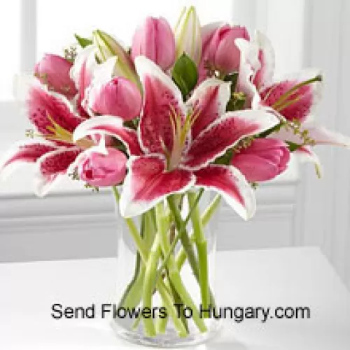 Lys roses et tulipes roses dans un vase en verre